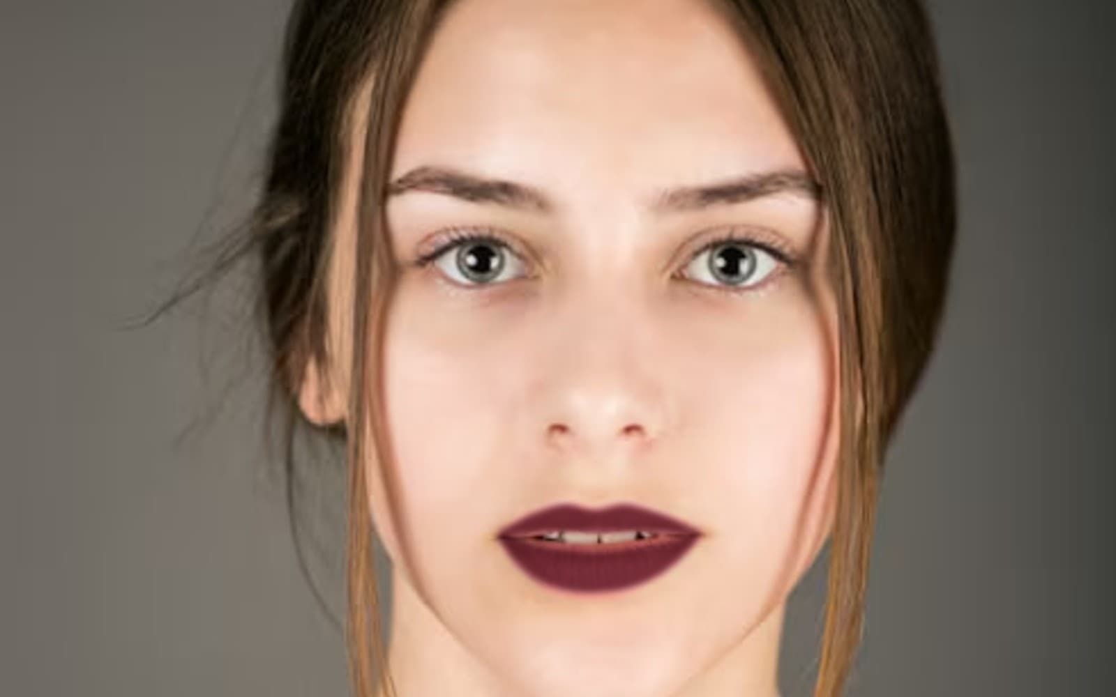 Close portrait of a model wearing a deep matte red lip