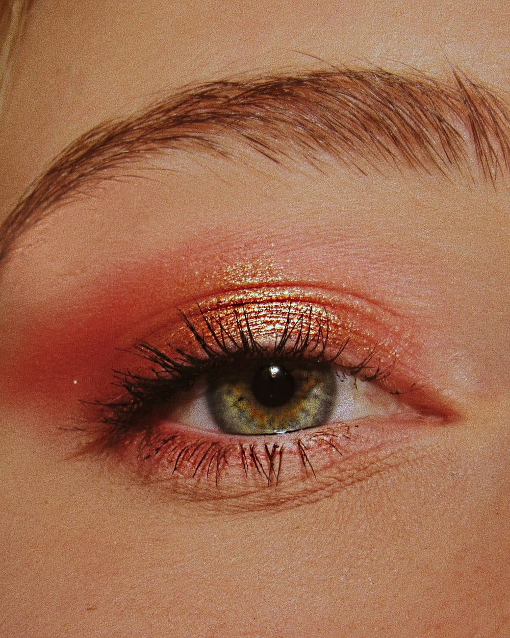 A warm coral and gold eye, blended soft to the brow