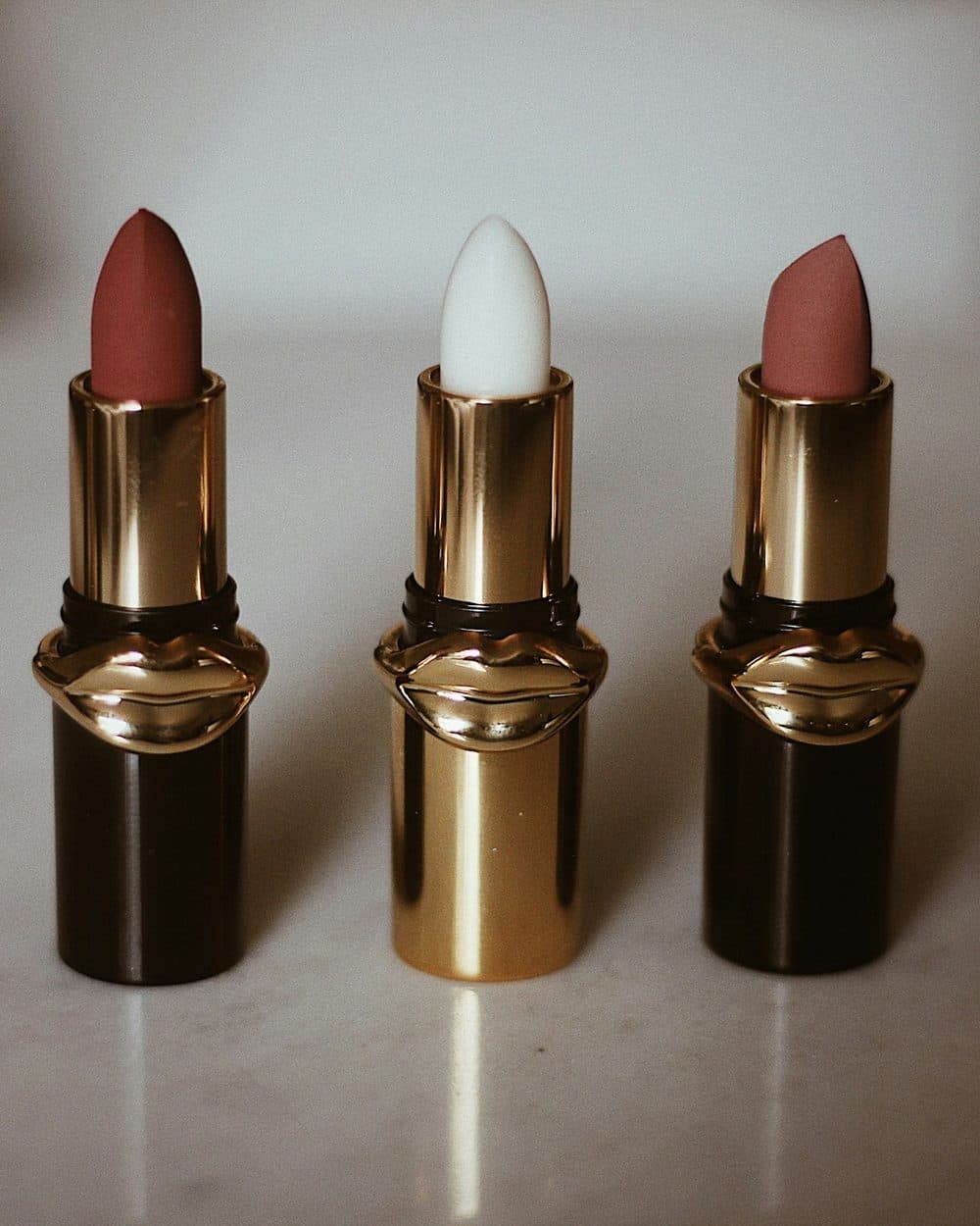 Rouge Velmora in its brass case, standing with two companion shades
