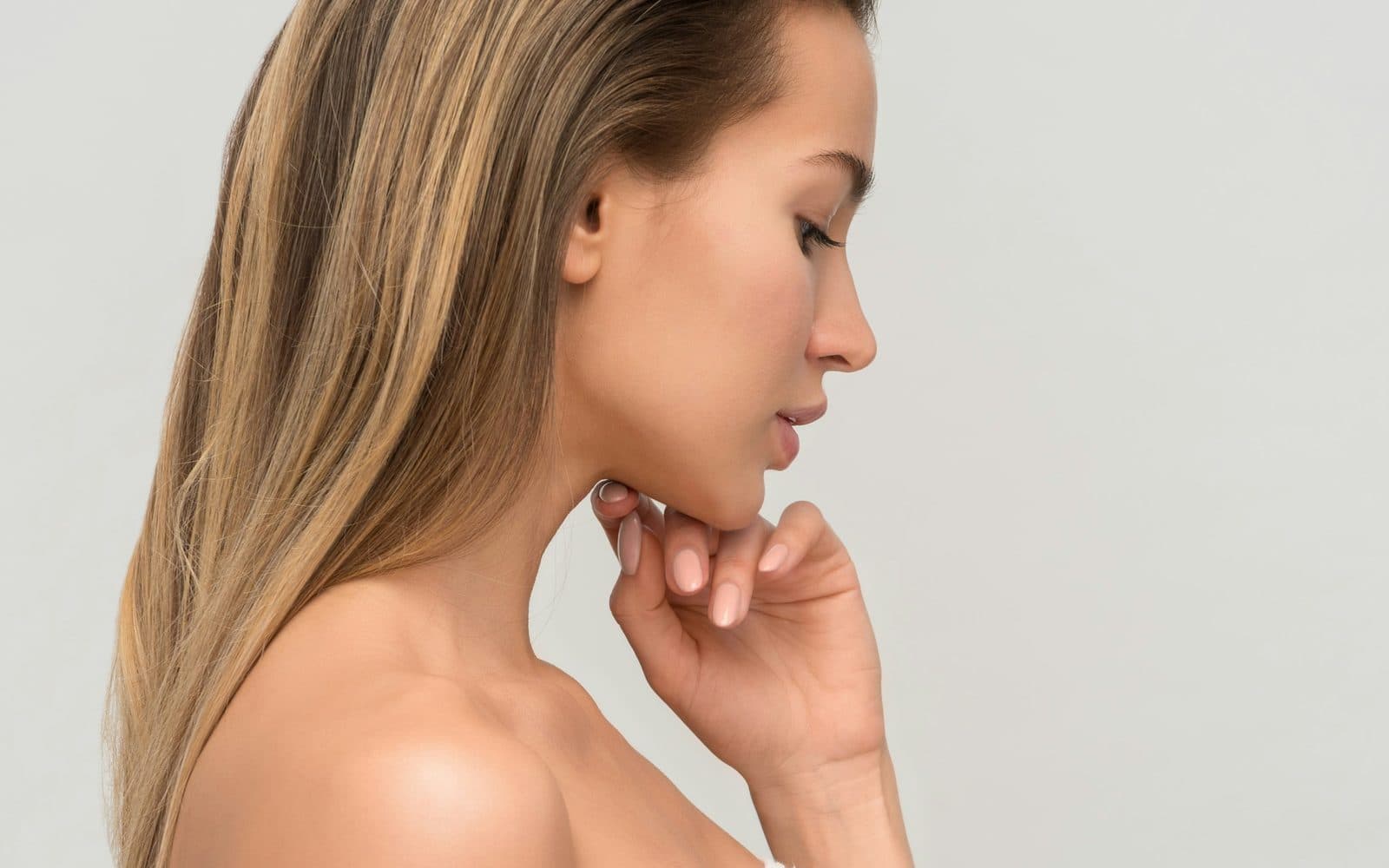 A woman in profile against a pale ground, skin left bare