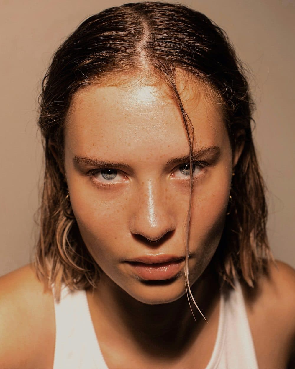 Dewy skin with a cream flush worn high on the cheek