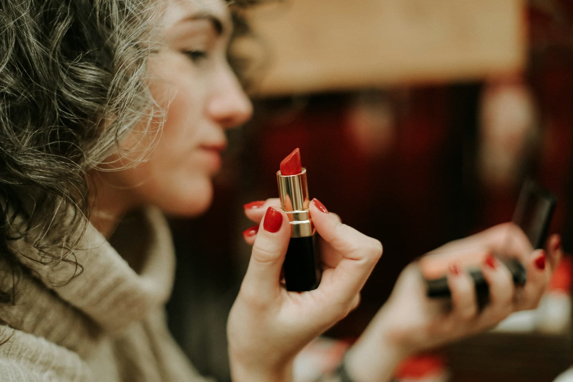 Model wearing a deep red satin lip in soft daylight